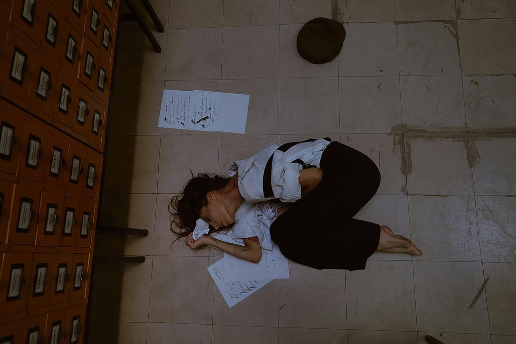 A woman lying on the floor unable to wake up due to sleep paralysis