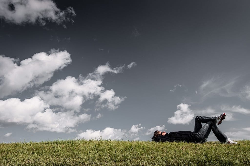 Person relaxing on grassy hill dreaming about my ex