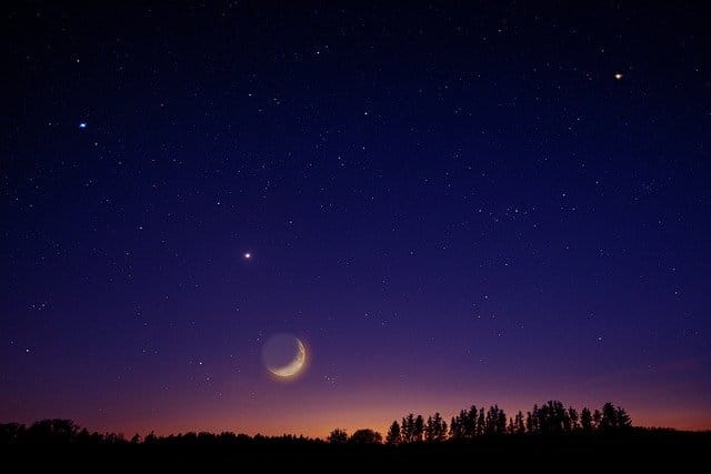 Starry night sky just before the sun's sunset and the moon rising as a symbol of moon astrology reading online.
