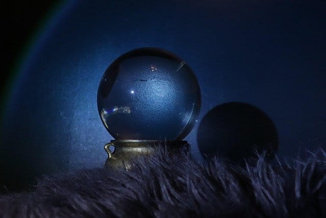 a crystal ball on a fur surface with dark background, representing the moon astrology reading.