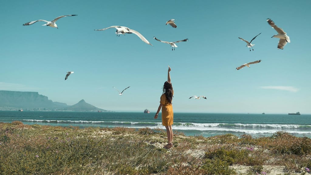 A woman enjoying slow mornings at the beach with the birds