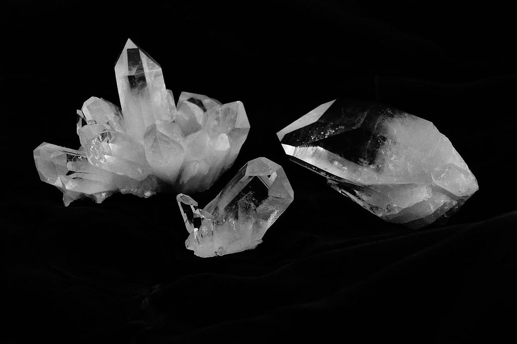 Three clear quartz crystals on black. dark feminine bedroom decor ideas.