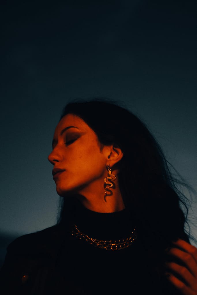 A beautiful woman with closed eyes at dark background